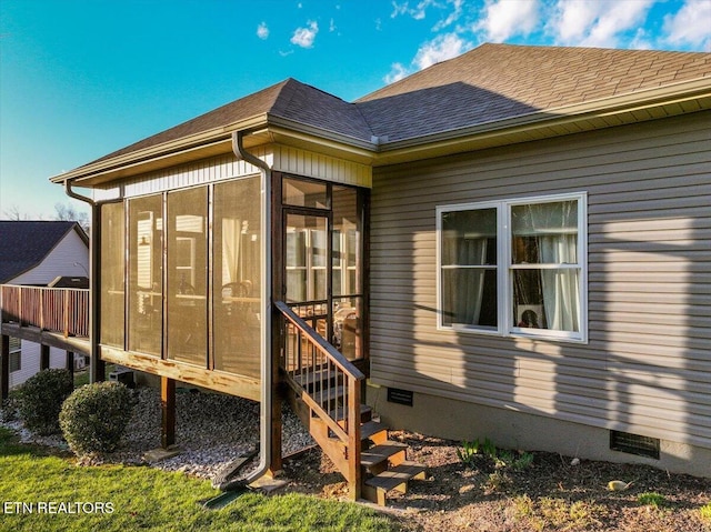 view of home's exterior featuring roof with shingles, crawl space, and a sunroom