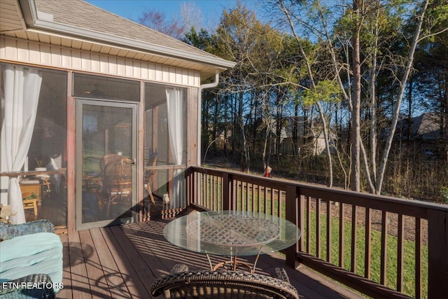 deck with outdoor dining space and a sunroom