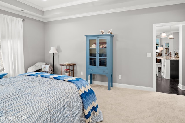 carpeted bedroom with ornamental molding and baseboards