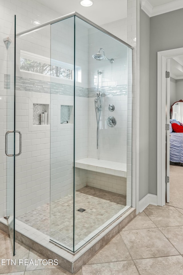 full bath featuring ornamental molding, a shower stall, baseboards, and tile patterned floors