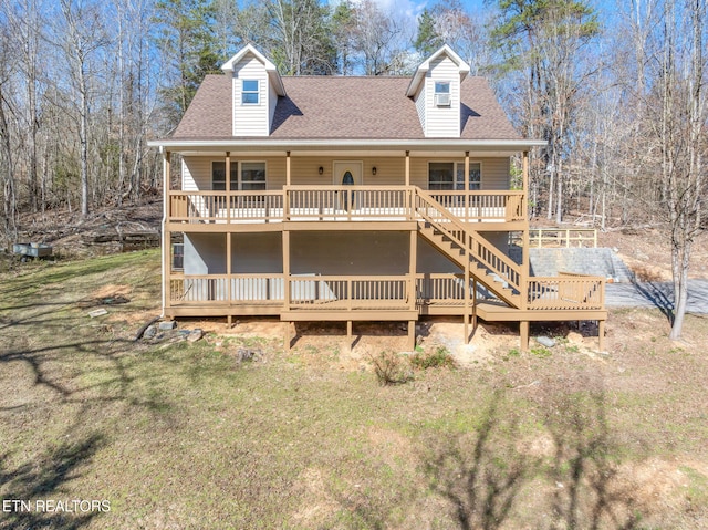 view of front of property featuring a shingled roof, stairway, a wooden deck, and a front lawn