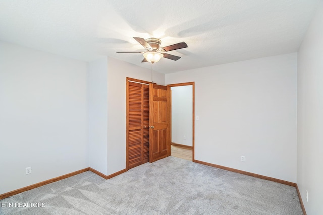 unfurnished bedroom with ceiling fan, a textured ceiling, carpet floors, baseboards, and a closet