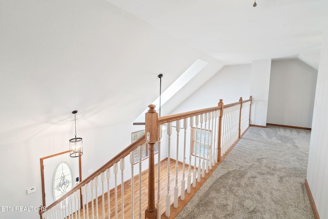 corridor featuring vaulted ceiling and carpet flooring