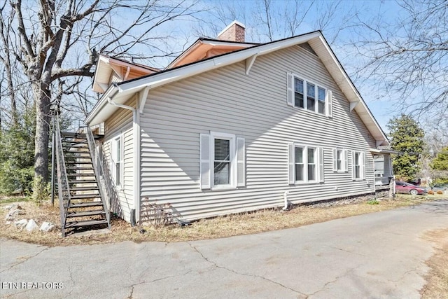 view of side of property with a chimney and stairway