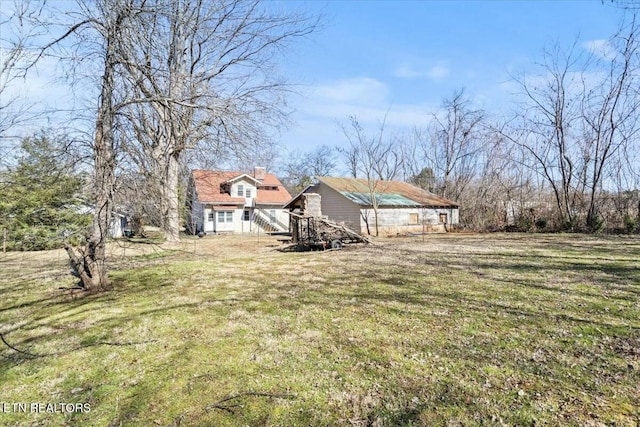 view of front of house featuring a chimney and a front yard