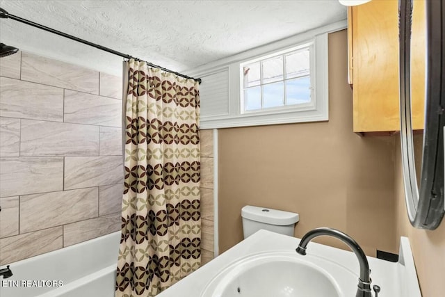 bathroom with a sink, shower / tub combo, toilet, and a textured ceiling