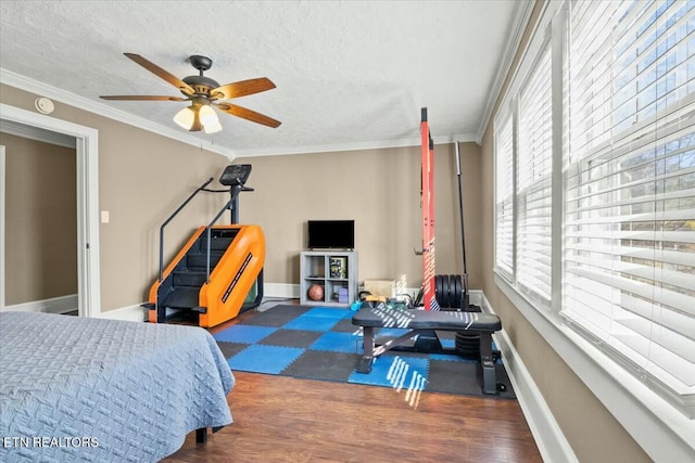 bedroom with ornamental molding, dark wood-style flooring, a textured ceiling, and baseboards