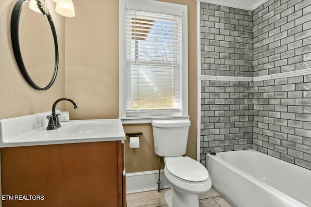 full bath featuring baseboards, vanity, and toilet