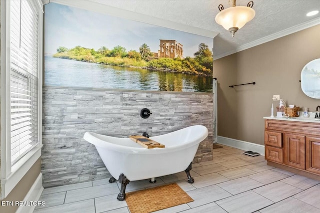 full bath featuring a textured ceiling, ornamental molding, a freestanding bath, and vanity