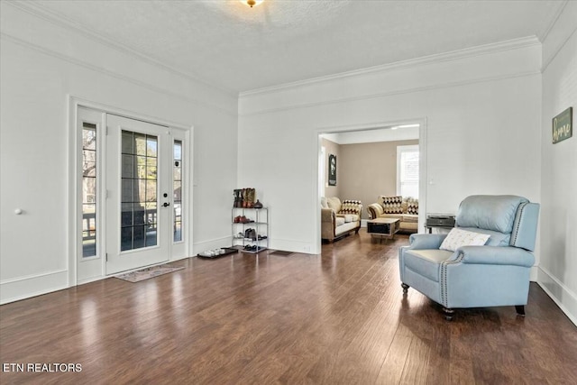 living area with baseboards, a textured ceiling, ornamental molding, and dark wood-type flooring