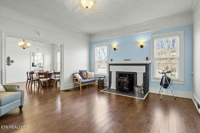 living area featuring dark wood-style floors, a textured ceiling, baseboards, and crown molding