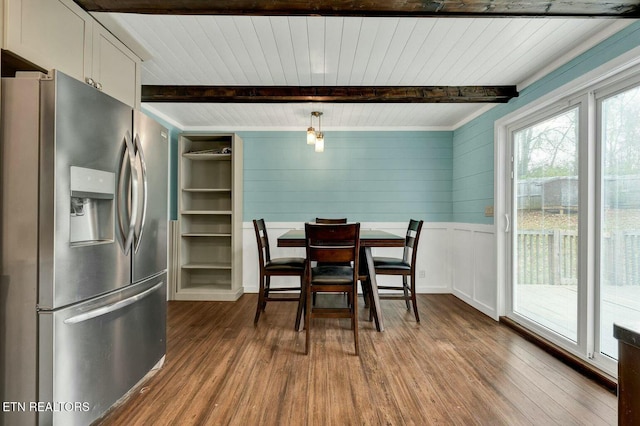 dining space featuring beamed ceiling and wood finished floors