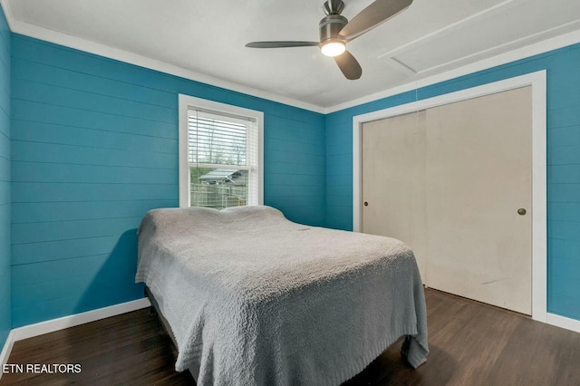 bedroom with a ceiling fan, attic access, baseboards, and dark wood-style flooring