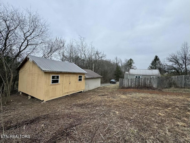 view of yard with an outbuilding and fence