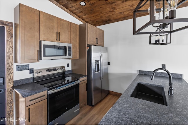 kitchen featuring brown cabinetry, lofted ceiling, wood ceiling, stainless steel appliances, and a sink