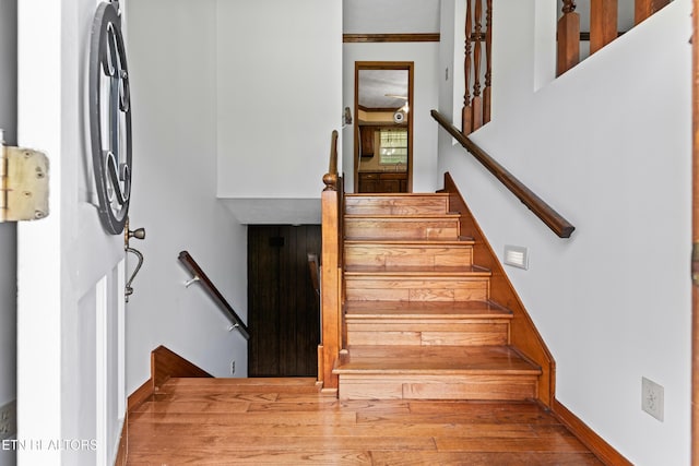 staircase with baseboards and wood finished floors