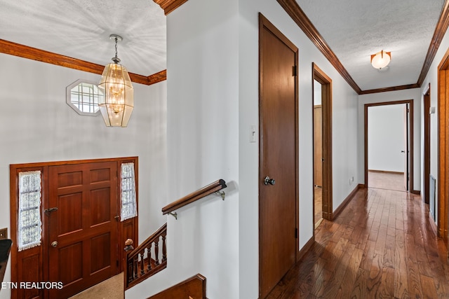 entrance foyer with a textured ceiling, baseboards, dark wood-style flooring, and crown molding