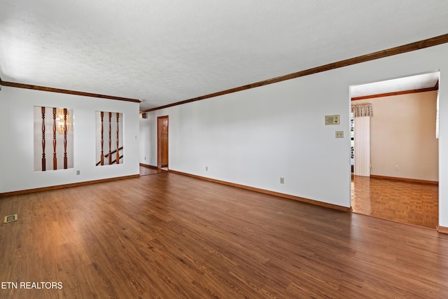 unfurnished living room featuring dark wood-style flooring, crown molding, visible vents, a textured ceiling, and baseboards