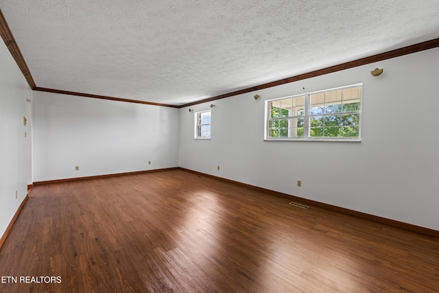 unfurnished room featuring baseboards, visible vents, wood finished floors, crown molding, and a textured ceiling