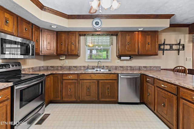 kitchen featuring stainless steel appliances, a sink, visible vents, ornamental molding, and light floors