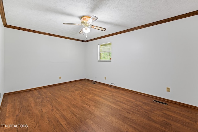 spare room with visible vents, a ceiling fan, ornamental molding, wood finished floors, and a textured ceiling