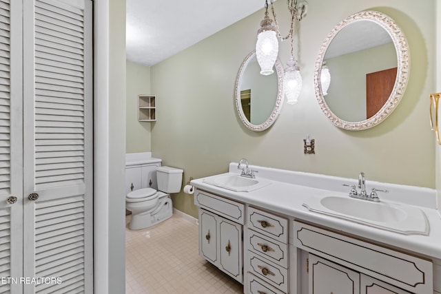 full bath featuring a sink, double vanity, toilet, and a closet