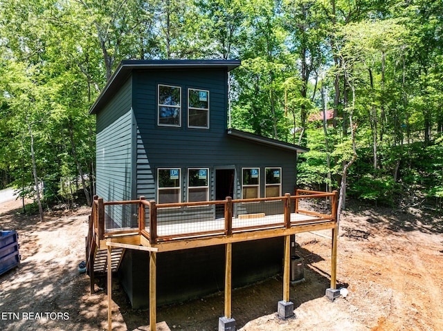 rear view of property with a deck, stairs, and central air condition unit