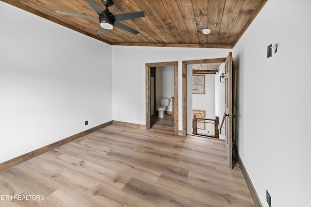 unfurnished bedroom featuring light wood finished floors, wooden ceiling, connected bathroom, and baseboards