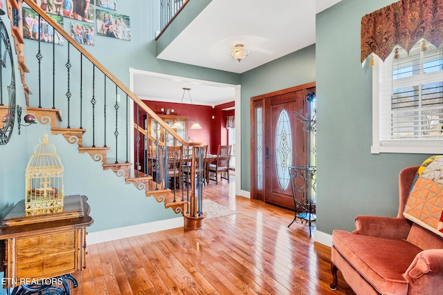 foyer featuring stairs, wood finished floors, and baseboards