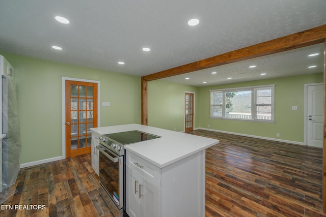 kitchen with a kitchen island, white cabinetry, open floor plan, light countertops, and appliances with stainless steel finishes