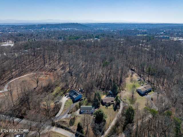 drone / aerial view featuring a wooded view