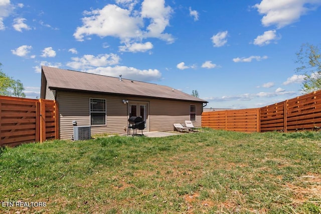 back of property featuring french doors, a lawn, a patio area, central AC, and a fenced backyard