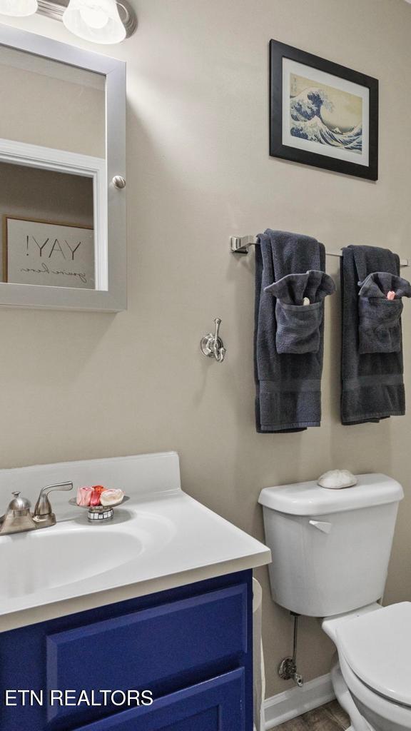 bathroom with baseboards, vanity, and toilet