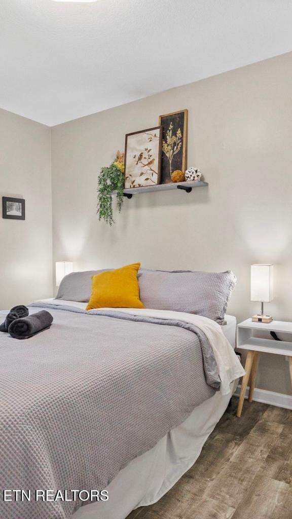 bedroom featuring baseboards and wood finished floors