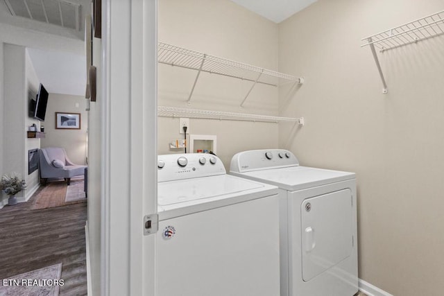 laundry area with laundry area, baseboards, visible vents, dark wood-style floors, and washing machine and clothes dryer