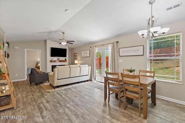 dining area with lofted ceiling, visible vents, baseboards, and wood finished floors