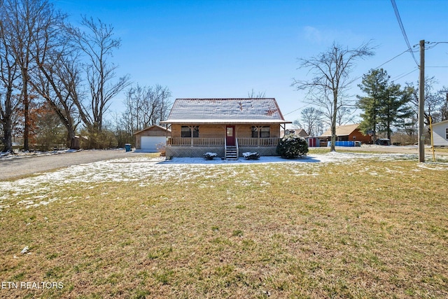 rear view of property featuring a porch, an outbuilding, a yard, and a detached garage