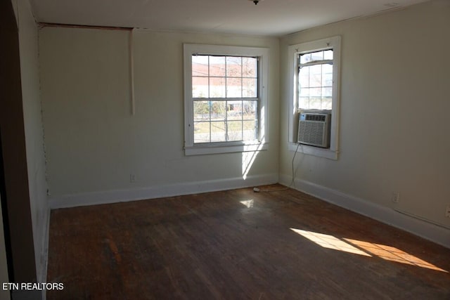 spare room with dark wood-style floors, cooling unit, and baseboards