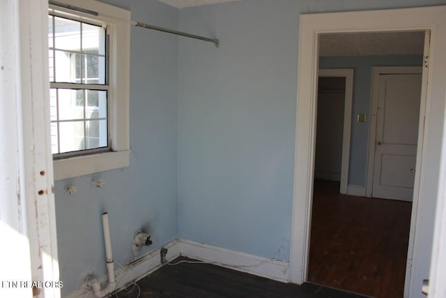 washroom with dark wood-style floors, laundry area, and baseboards