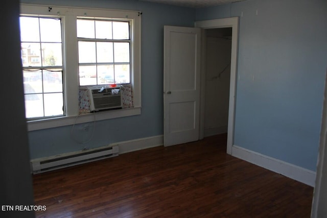 unfurnished room featuring a baseboard radiator, baseboards, dark wood finished floors, and cooling unit