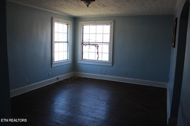 empty room featuring baseboards, dark wood-type flooring, and a textured ceiling