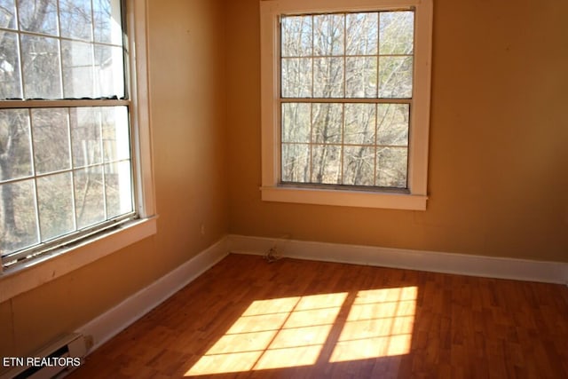 unfurnished room featuring wood finished floors and baseboards