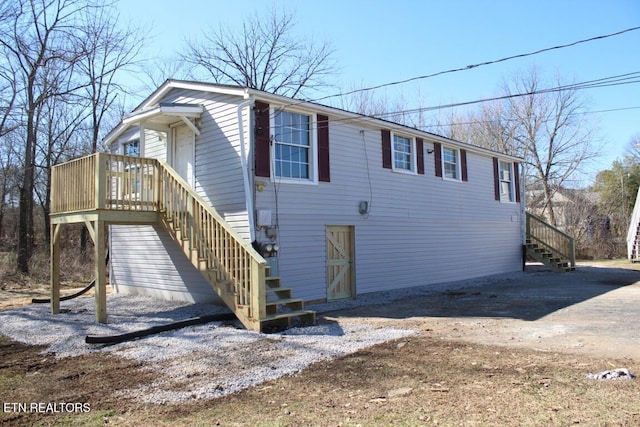 view of front of home featuring stairway and dirt driveway