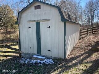 view of shed featuring fence