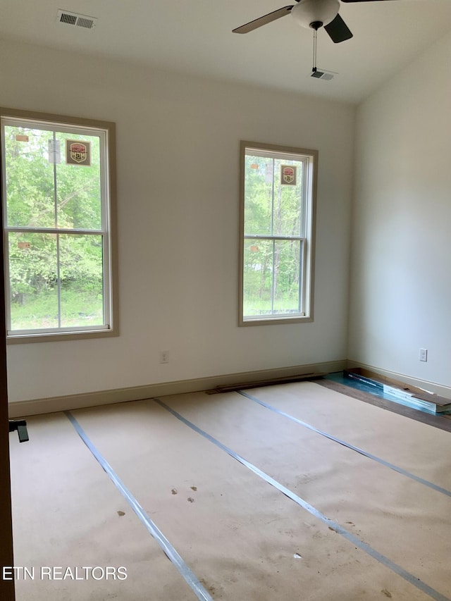 spare room with ceiling fan, visible vents, and a healthy amount of sunlight