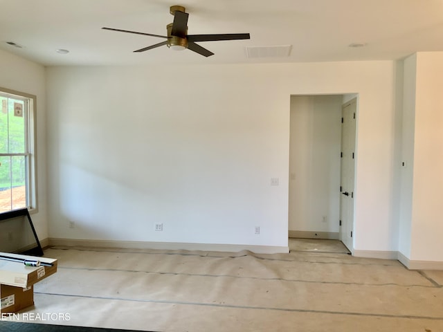 empty room featuring baseboards, visible vents, a ceiling fan, and concrete floors