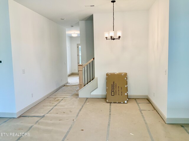 unfurnished dining area with baseboards, stairway, visible vents, and an inviting chandelier