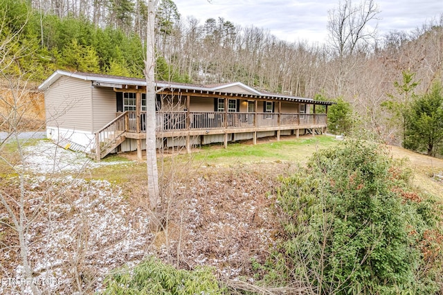 back of property with a wooded view