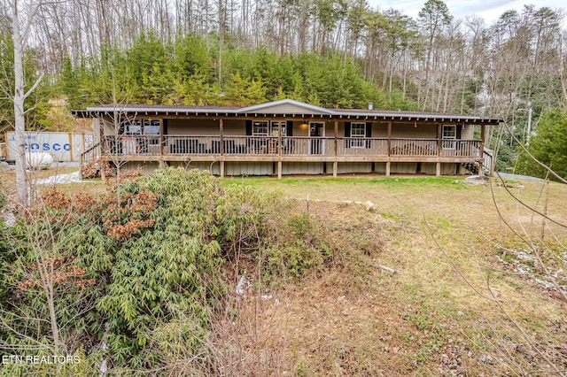 rear view of property featuring a wooden deck