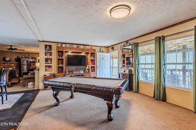 game room with a textured ceiling, carpet floors, and ornamental molding